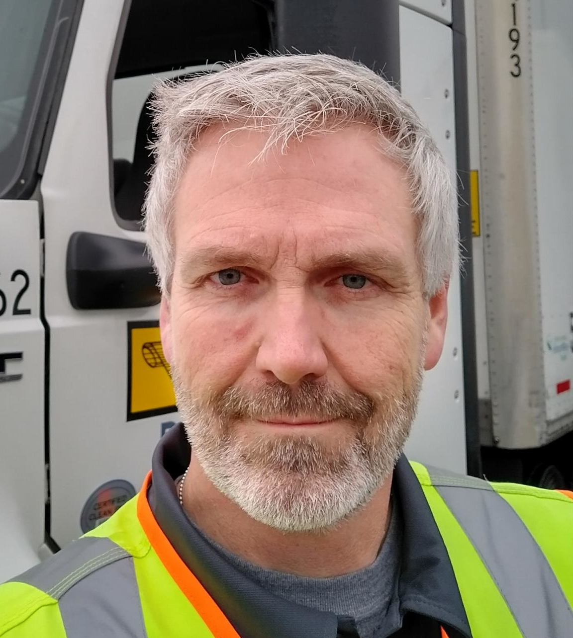 Picture of Ed in front of his truck at work.
